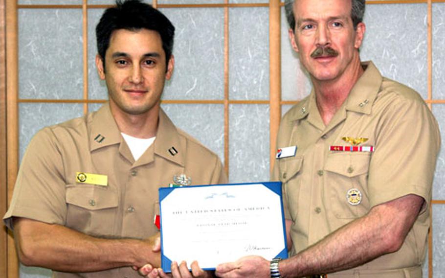 Lt. Sean Kido, left, receives a Bronze Star Medal with combat V this month from Kitty Hawk Strike Group Commander Adm. Rick Wren earlier this month.