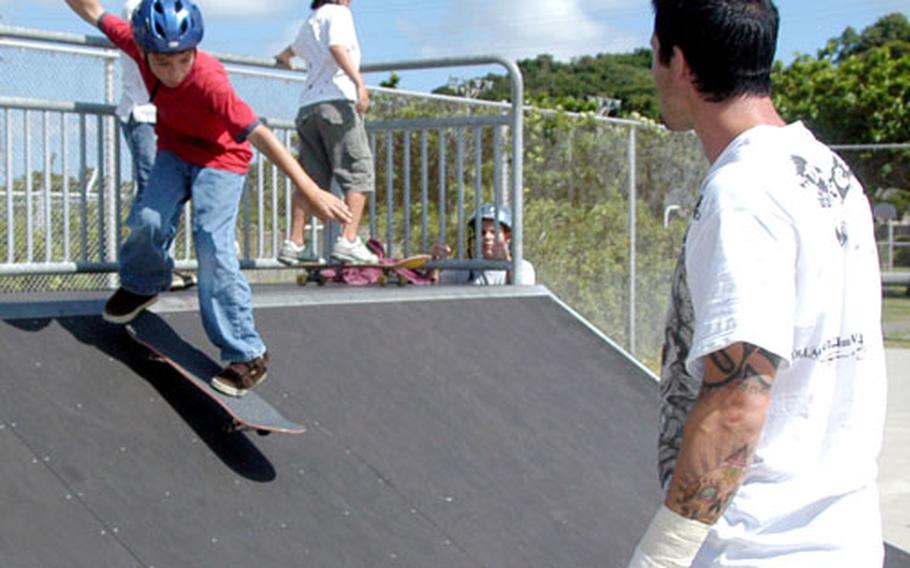 Professional skateboarder Chad Knight critiques young skaters' technique as they roll down a ramp during a three-day skateboarding camp at Camp Courtney Tuesday.