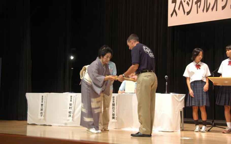 Okinawa chapter chairwoman Michiko Yasuda presents a certificate of appreciation to Kadena Air Base 18th Wing commander Brig. Gen. Brett Williams.