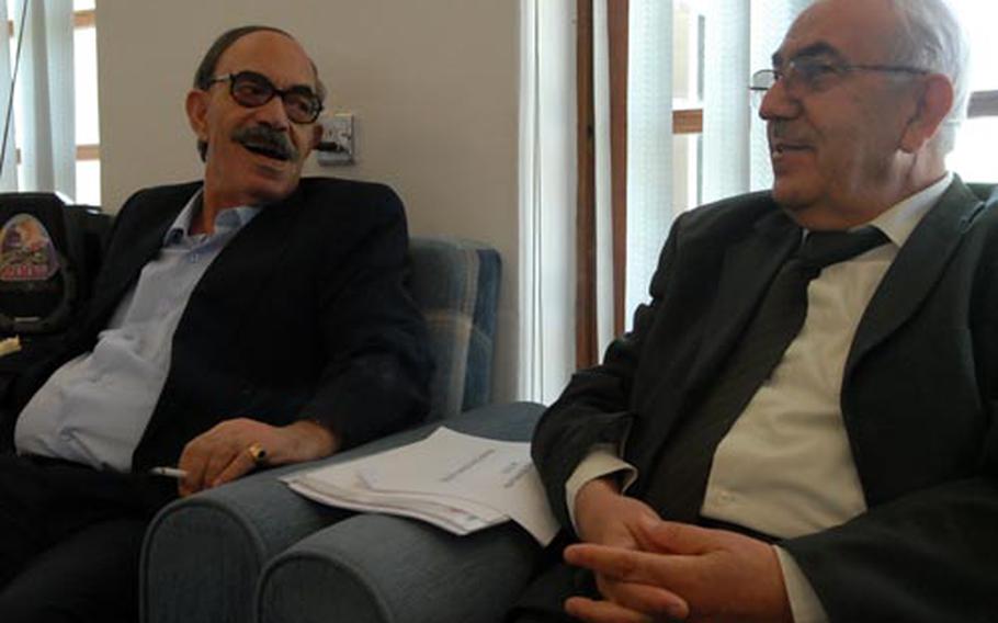 Sheikh Manaa Abdullah Alobaydi, director general for Iraq’s Northern Oil Co. (left), shares a laugh Monday in Kirkuk with Hunar Najeeb Hassan, director general of Northern Gas Co. The two met with other energy officials to prepare for a national energy conference.