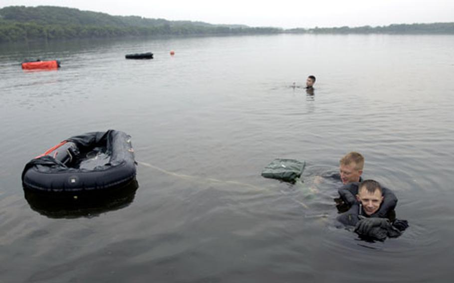 Staff Sgt. Ben Thomas, center, a Survival Evasion Resistance Escape specialist at Misawa Air Base, Japan, instructed 14th Fighter Squadron pilots in water survival training Wednesday in Lake Ogawara.