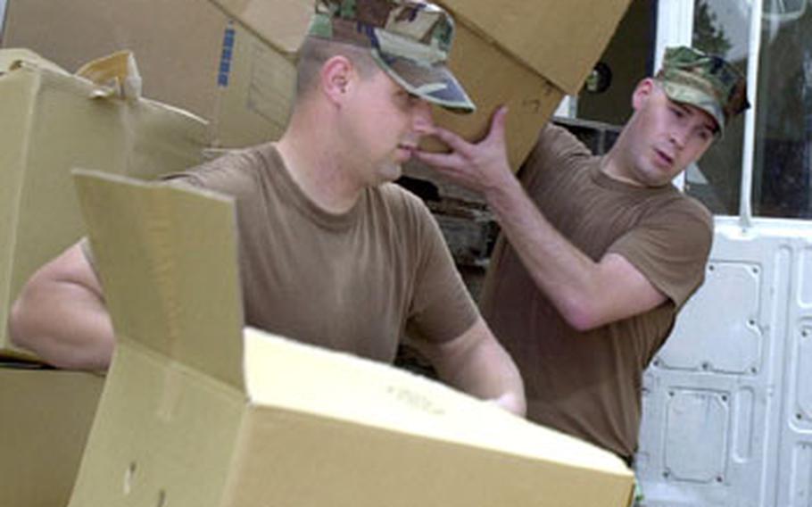Petty Officer 2nd Class Brent Zimmerman, left, and Petty Officer 3rd Class Lucas McConn break down boxes to load into a truck at the NAF Atsugi recycling center.