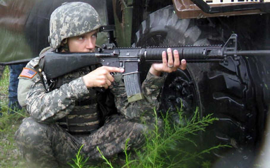 A rain-drenched Bravo Company soldier takes cover while under simulated fire from "enemy" guerrilla fighters in a mock village Thursday at Camp Hovey. The mission was part of a five-day exercise for the 2nd Infantry Division&#39;s 1st Battalion, 72nd Armor Regiment.