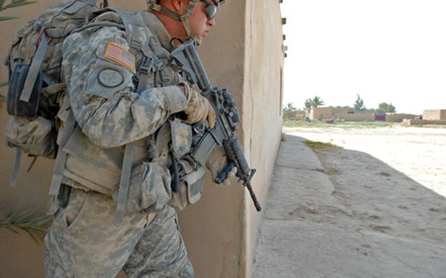 Sgt. 1st Class Richard Edwards, a platoon sergeant in Fox Troop, 2nd Squadron, 3rd Armored Cavalry Regiment, peeks around the corner of a home Friday in Samood, Iraq, while searching homes during Operation Saber Pursuit. The long-expected operation aims to clear al Qaeda cells from the southern part of Diyala province.