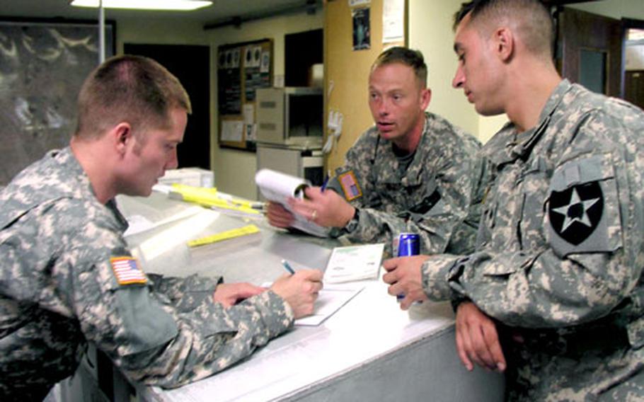 At K-16 Air Base in Seoul, members of a U.S. Army Black Hawk helicopter crew weigh their next move in planning a flight they were trying to make to Pyeongtaek during a day of bad weather advisories. From left are Chief Warrant Officer 2 Seth Thompson, lead pilot for the day’s missions; Chief Warrant Officer 2 Robert Herlt, co-pilot; and Sgt. Marko Zarkovic, crew chief. All are with Company C, 2nd Battalion, 2nd Aviation Regiment, part of the 2nd Infantry Division’s 2nd Combat Aviation Brigade.