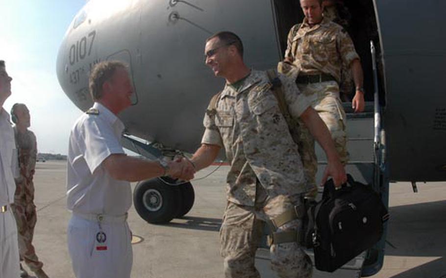 British Rear Adm. Christopher Snow, deputy commander for Strike Force NATO, greets a U.S. Marine getting off an Air Force C-17 that landed in Naples, Italy, on Wednesday afternoon, bringing home 16 Strike Force NATO forces from a six-month deployment to Afghanistan.