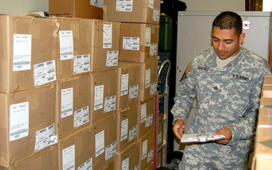 Sgt. Jose Sanchez, Headquarters and Headquarters Detachment, 41st Signal Battalion, makes notes on the stock of rubber boots in his supply room Wednesday at Camp Coiner. Sanchez runs the supply room that recently won a Supply Excellence Award at the major command level of competition. His unit will go on to compete at the Department of the Army level of competition.