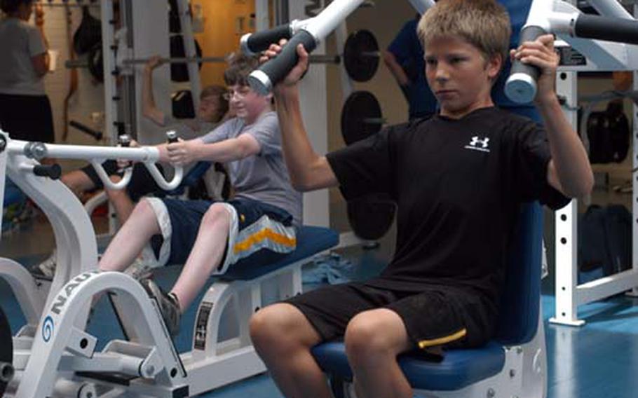 Colin McDonnell, 13, foreground, and Doug Rean, 14, work out at the gym at RAF Lakenheath. The teens have been training three mornings a week with gym staff since June as part of the youth summer fitness program at the base.