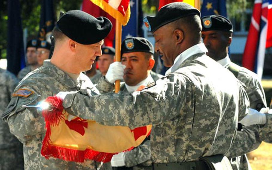 U.S. Army Garrison Darmstadt commander Lt. Col. David Astin, left, and Command Sgt. Maj. Harold Littlejohn, roll up the garrison colors during the closure ceremony on Tuesday. The garrison is closing it gates in Darmstadt, Germany, after 63 years.