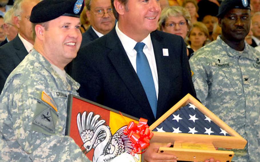 Col. Ray Graham, left, U.S. Army Garrison Hessen commander, and Hanau&#39;s Lord Mayor Claus Kaminsky show off the presents they exchanged following the garrison&#39;s closure ceremony on Pioneer Kaserne in Hanau, Germany, on Thursday. A standing room-only crowd attended the ceremony that brought the U.S. Army&#39;s 63-year presence in the city to an end.