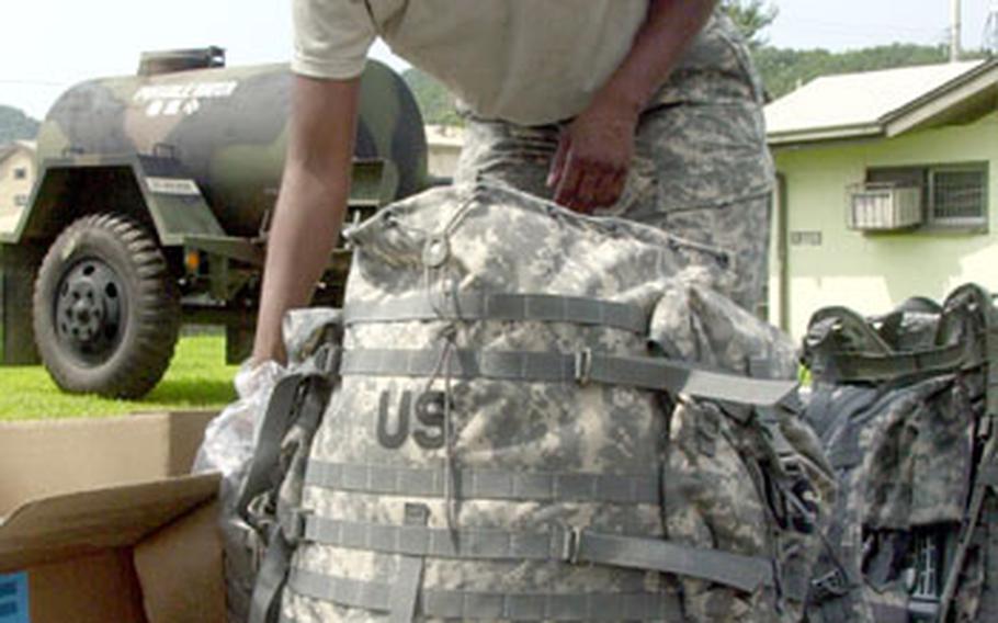 Pfc. Stephanie Clavon of Special Troops Battalion, 1st Brigade, 2nd Infantry Division, packs up her new rucksack with cold weather gear and other issued items Friday outside the Camp Hovey gym. Program Executive Office-Soldier is distributing the new generation of gear to thousands of soldiers in South Korea.