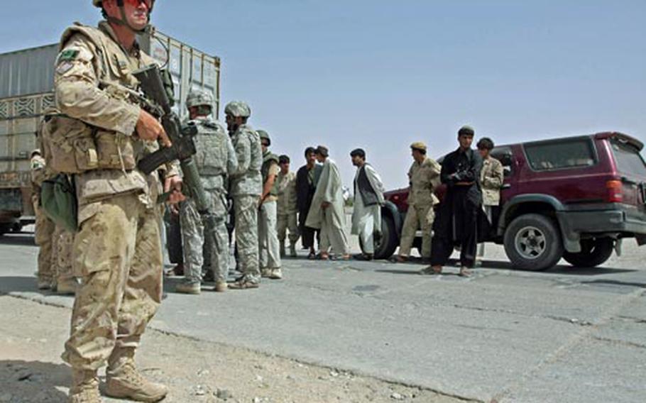 Canadian Sgt. Ole Fredericksen keeps an eye out on a long line of traffic stopped on the highway in Maiwand district, as Canadian and U.S. army officers try to sort out what happened when a group of Afghan private security guards opened fire on a group Canadian soldiers Saturday in Afghanistan’s Kandahar province, thinking they were under attack from the Taliban. A Canadian soldier was fatally shot.