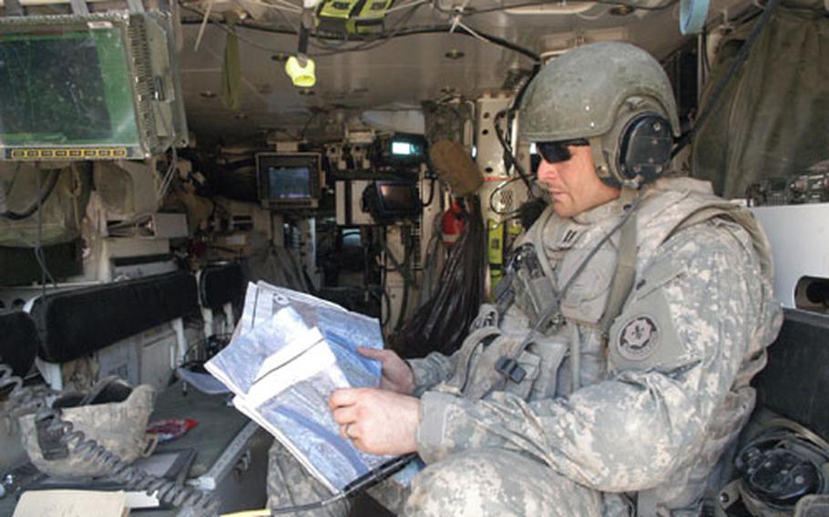 Capt. Michael Martin, commander of Palehorse Troop, 2nd Squadron, 2nd Stryker Cavalry Regiment, looks over the targets of homes rigged with explosives before calling in an airstrike.