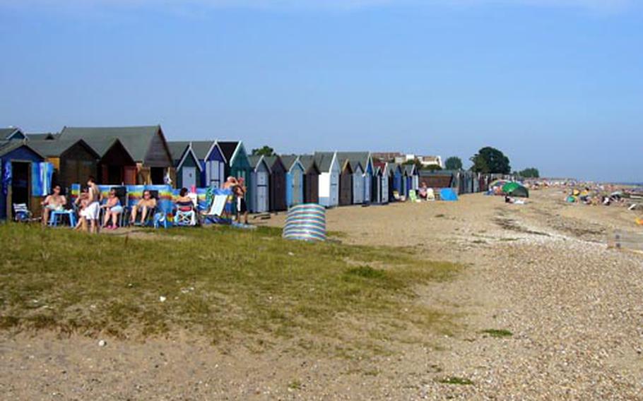 A long row of bungalows lines the shore in West Mersea, a small beach town on the island of Mersea.