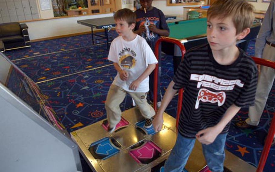 Brothers George, left, and Maxwell Taylor bust a move with a video dancing game at the RAF Mildenhall youth center on a recent afternoon. George, 9, and Taylor, 11, both attend British schools but spend the summers at the base facility.