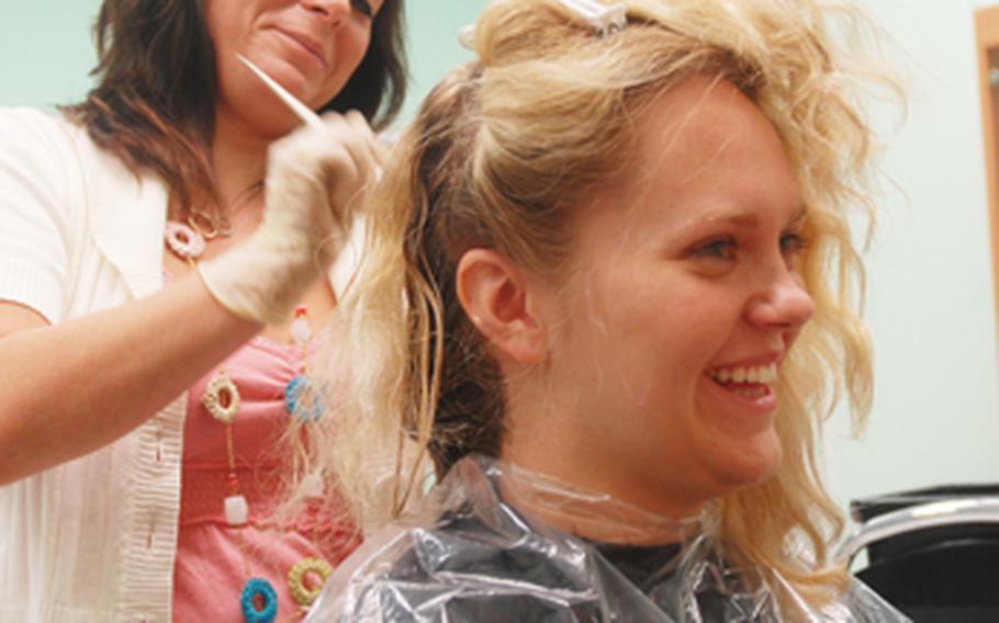 Hairdresser Laurel Still gets to work on Nicole Rebugio’s hair at Stylique on Monday.