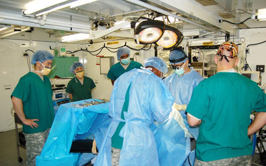 Members of the 121st Combat Support Hospital perform surgery at a Camp Humphreys field hospital during a training exercise Tuesday.