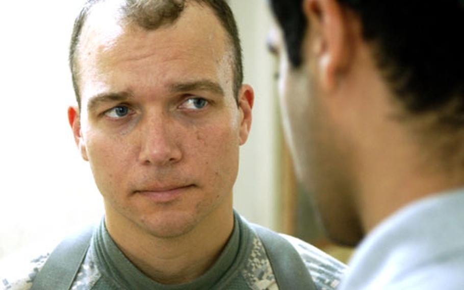 Maj. Tim Hunt, 2nd Stryker Cavalry Regiment's liaison to the Diyala provincial government, listens to his interpreter about an issue on Monday.