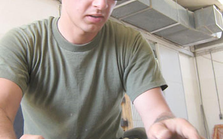 Cpl. Cezary Swirydziuk, 23, an electrical equipment specialist from Chicago, replaces a part in a generator last month at the utilities
section of Engineer Operations Company, Marine Wing Support Squadron 172 at Al Asad Air Base in Anbar province, Iraq. The squadron is based on Okinawa and deployed to Iraq in the spring.