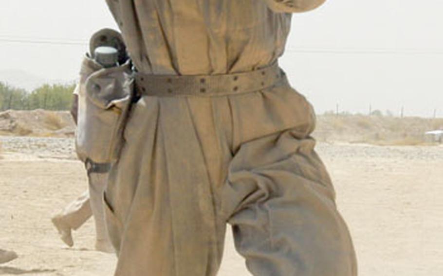 A police trainee practices advancing under fire at the Kandahar Regional Police Training Center in southern Afghanistan. Trainees spend eight weeks at the center learning basic paramilitary and counterinsurgency skills taught by trainers from the U.S. Army, Royal Canadian Mounted Police and the U.S. security contractor DynCorp.
