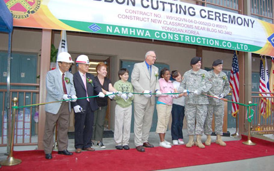 Officials from Yongsan Garrison, Seoul American Middle School and Namhwa Construction Co., along with SAMS students, cut a ribbon officially opening the school’s newest building.