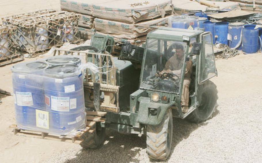 Lance Cpl. Cesar V. Lazo with Marine Wing Support Squadron 172, moves barrels of Rhino Snot at a construction site at Combat Outpost Rawah, Iraq in April 2008.