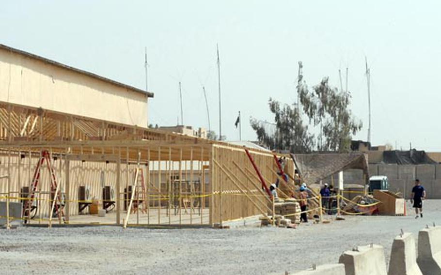 A construction crew works on the addition to Forward Operating Base Falcon’s main gym on Tuesday. The project is one of several planned improvements to the base, even though officials are unsure what the base's status will be next summer.