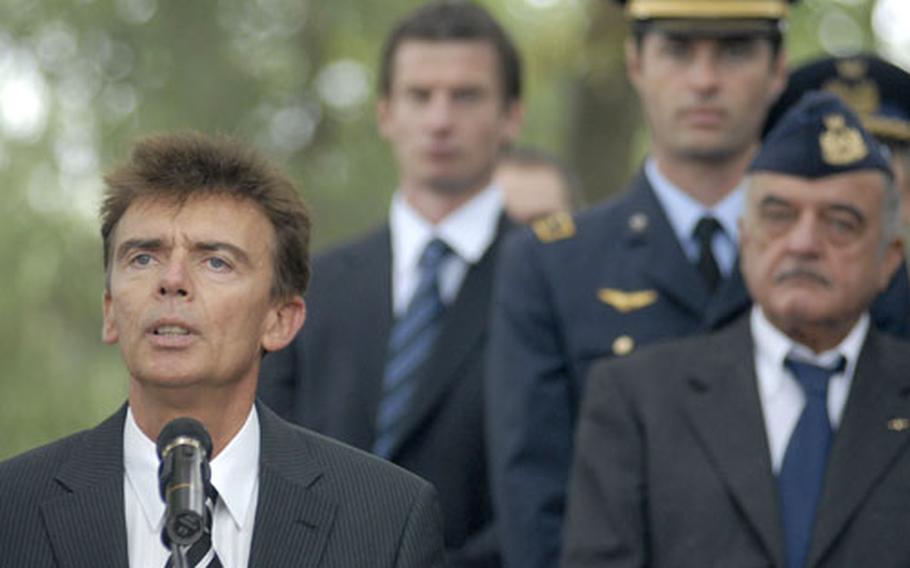 Klaus Layes, the mayor of Ramstein Villiage, speaks to a gathering during a ceremony Thursday to remember those who died 20 years prior in a devastating air show crash at Ramstein Air Base. Three aircraft from Italy's precision-flying team Frecce Tricolori collided during an aerial maneuver killing 67 bystanders and injuring more than 500 others. The three Italian pilots died.