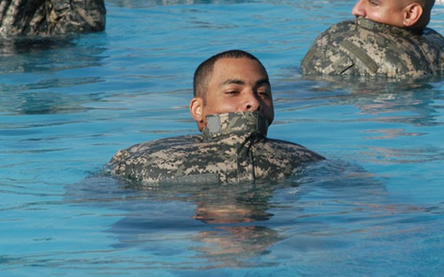 Pfc. Gary Odom uses his inflated Army Combat Uniform jacket to float through the pool.