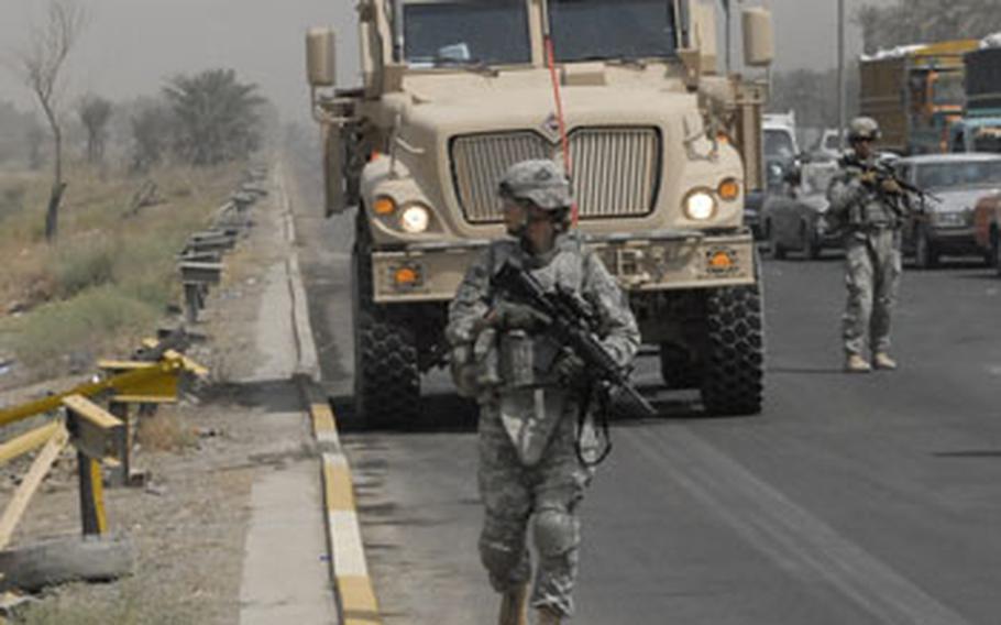 Cpl. Rebecca Baxter, a medic with Headquarters and Headquarters Company of the 1st Brigade Combat Team, 4th Infantry Division, scans the fields along the busy Dora Highway during a patrol mission last month. U.S. troops regularly patrol most of the district every day, despite far fewer security incidents than a year ago.