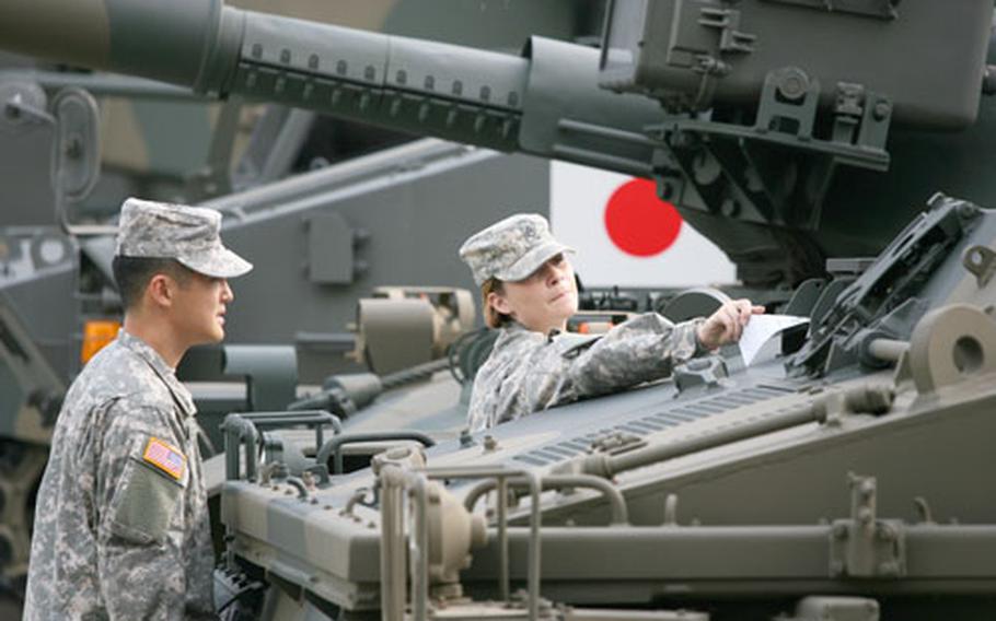 Spc. Sean Kagawa and Staff Sgt. Katie Verinder examine a Japan Ground Self-Defense Force armored vehicle on display at the JGSDF Public Affairs Center. They were among five Camp Zama soldiers and five Okinawa-based Marines who spent a week touring JGSDF installations as part of the Observer Exchange Program.
