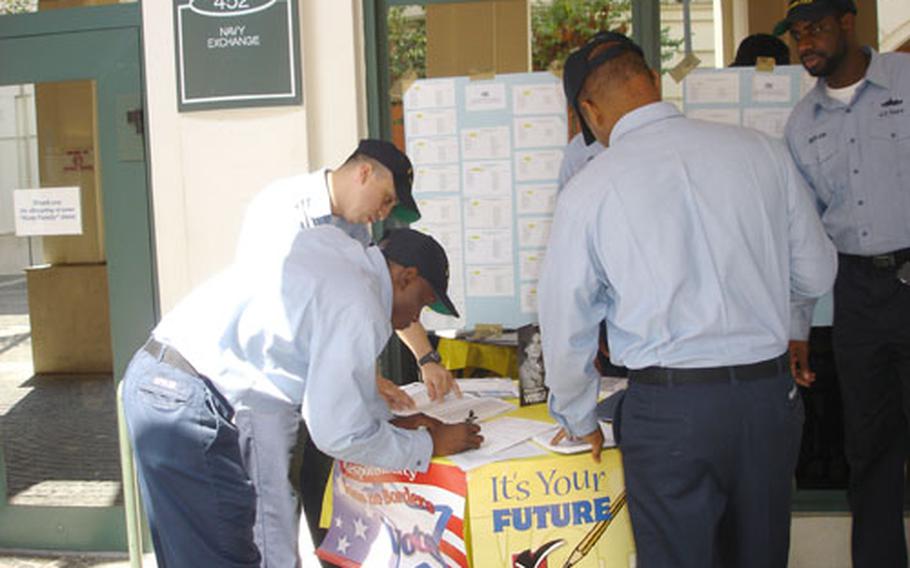 Volunteers at Naval Support Activity Naples in Italy help people apply for absentee ballots.