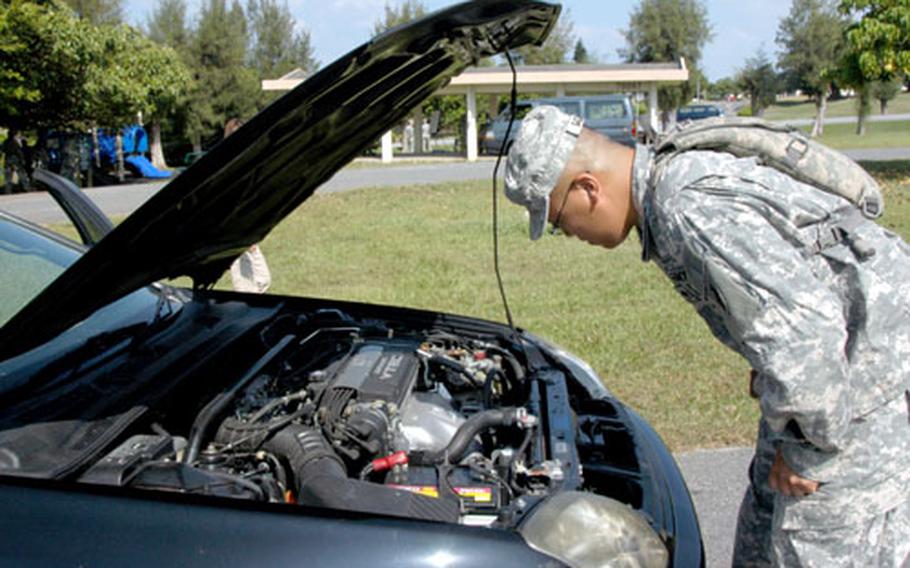 Spc. Mark Sasamoto, an ammunition specialist with the 83rd Ordnance Battalion, searches a car for an improvised explosive device. The task was one of several Sasamoto had to complete as part of the warrior challenge.