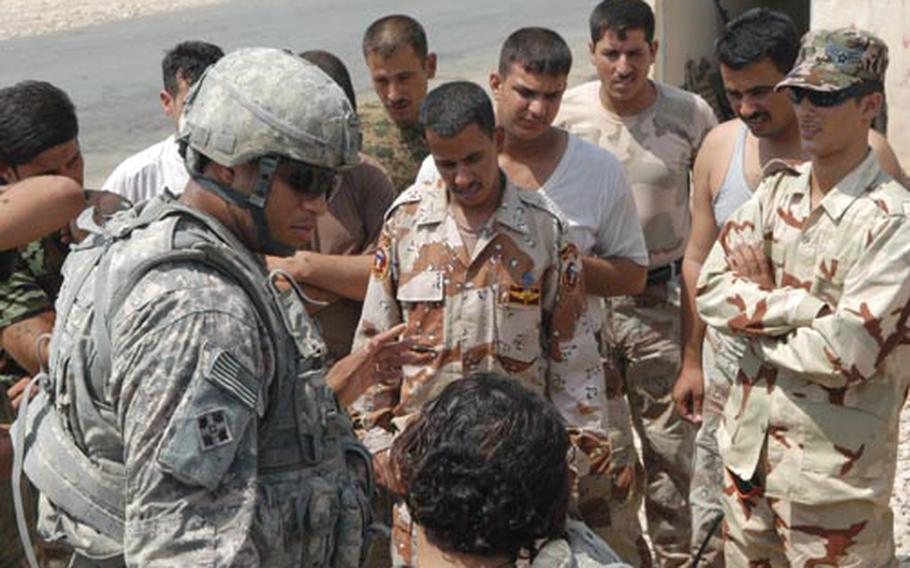 Sgt. 1st Class Jon Smith (left), 35, of Petersburg, Va., the lead medical adviser on a military transition team attached to 4th Brigade, 1st Iraqi Army Division, talks to Iraqi soldiers at the closest checkpoint to Khanaqin.