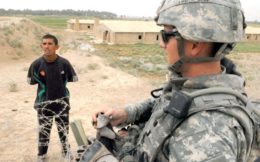 1st Lt. Slade Thorpe, a platoon leader in Company A, 1st Battalion, 35th Armor Regiment, talks with a farmer south of Baghdad to find out who owns the chicken farms in the background. The farmer told Thorpe that a sheikh in a home kitty corner to the farms owns them.