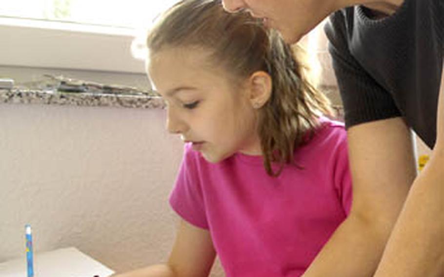 enw00HMSKUL-3 LANDSTUHL, GERMANY Julie Gorske helps her daughter Sarah, 10, with math at their Kaiserslautern area home Sep. 2nd.
