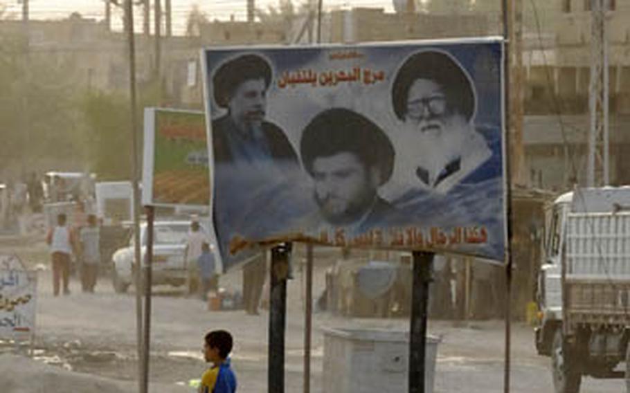 A young boy in Hussaniyah stands under a billboard of prominent Mahdi Army figures. U.S. troops in the city said they haven’t had direct confrontation with the group in recent months, but know it stills has a strong presence in the city.