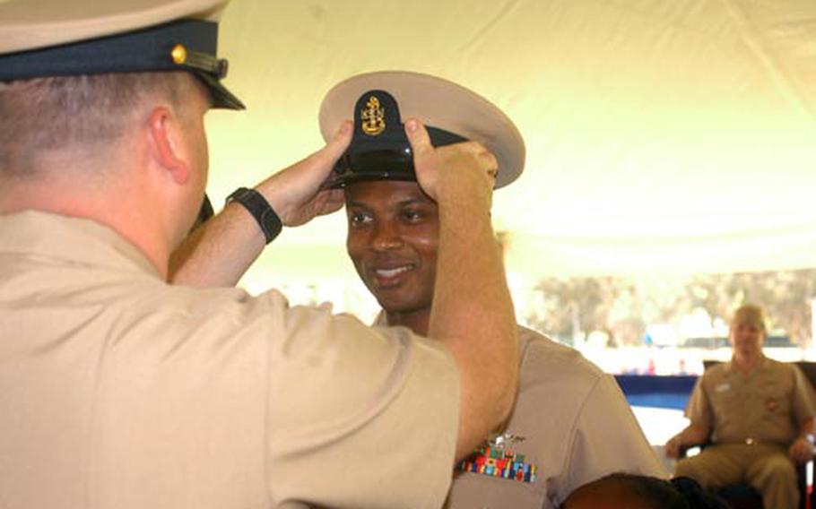 Newly promoted Chief Petty Officer Duane Daugherty receives his hat after having his anchors pinned to his collar, during the pinning ceremony in Naples, Italy, on Tuesday.