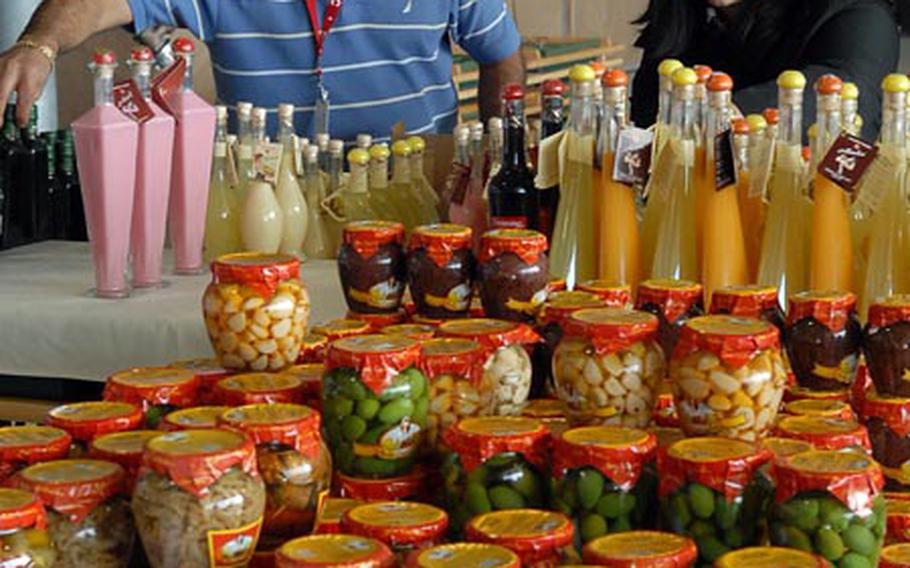 Lino Preziusco and Tina Tartaglio set up their Italian Wines & Gifts Lino & Romenio stand Tuesday in Hangar 1 at Ramstein Air Base, Germany, in preparation for the Ramstein Welfare Bazzar, which starts Thursday.