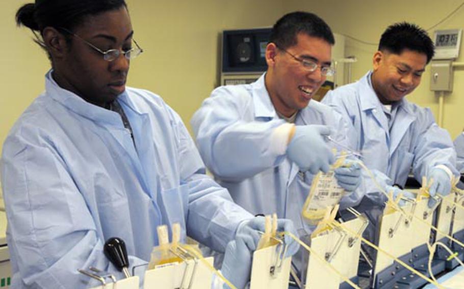Spc. Dana Thomas, left, 28, from Chicago, and other lab technicians massage packs of plasma to defrost them at the Armed Services Blood Bank Center on Camp Lester, Okinawa. In addition to plasma, the center also produces platelets and cryoprecipitate-rich plasma from blood donations. The center, which supports all U.S. Pacific Command’s blood needs, says it gets harder every year to fill the bank as the pool of available donors continues to shrink due to overseas deployments.