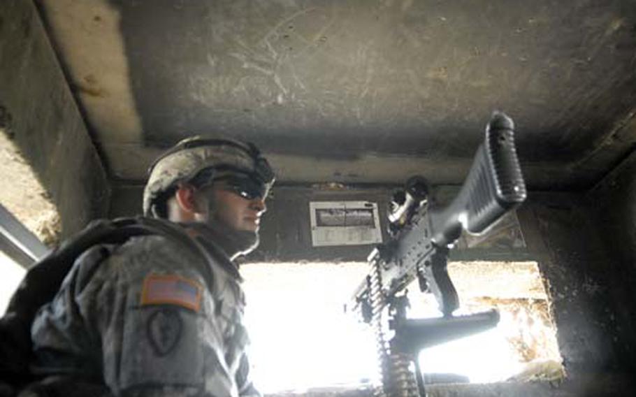 Pfc. Robert Young of the 2nd Battalion, 11th Field Artillery, mans a guard post at the gates of Camp Taji in Iraq. Troops say the lack of violence in the area is an encouraging sign of stability, but having fewer attacks makes it challenging to stay focused on their jobs.