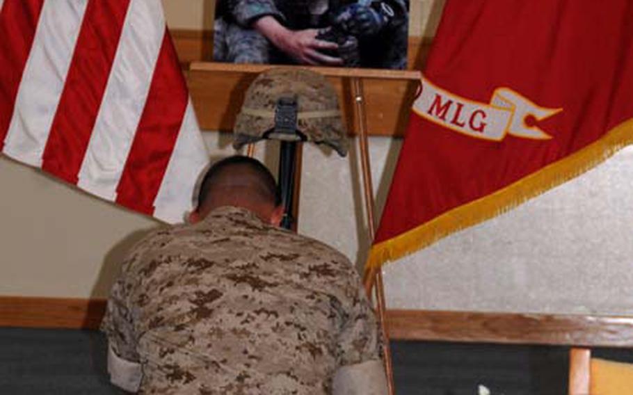 A Marine pays his final respects to 1st Lt. Nicholas A. Madrazo at a memorial service at the Camp Kinser, Okinawa, chapel Friday. Madrazo, 25, of Bothell, Wash., was assigned to Combat Logistics Regiment 37 and was killed in Afghanistan Sept. 9.