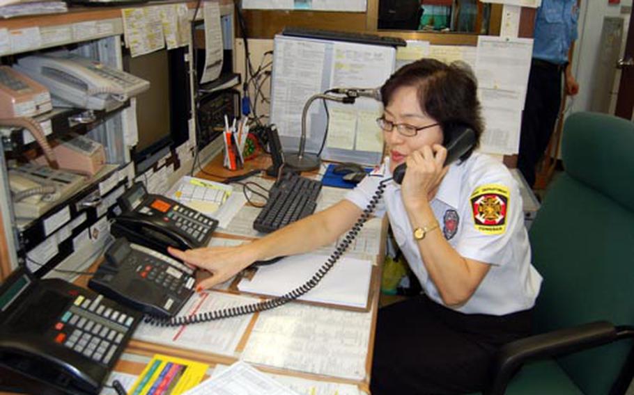 U.S. Army Garrison Yongsan Fire Department dispatcher Kim Kyong-sun takes a phone call at her desk Friday. Kim is one of the winners of the 2008 U.S. Forces Korea Civilian Employee of the Year Award.