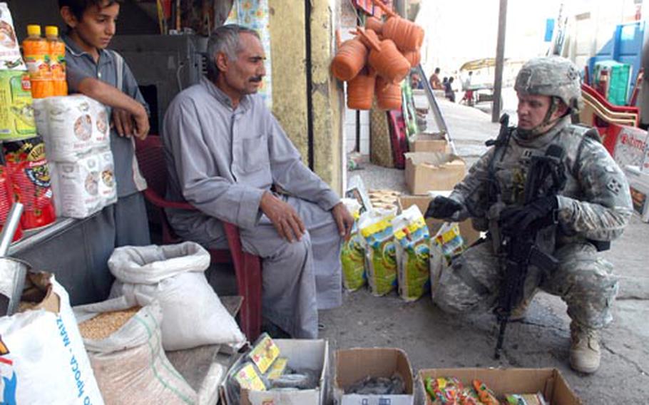 Capt. Alexander Rasmussen, commander of Company D, 1st Battalion, 8th Infantry Regiment, speaks to a small-business owner during an operation on Wednesday. U.S. and Iraqi soldiers are waging a two-headed fight in the city with security and reconstruction operations geared toward stabilizing the region.