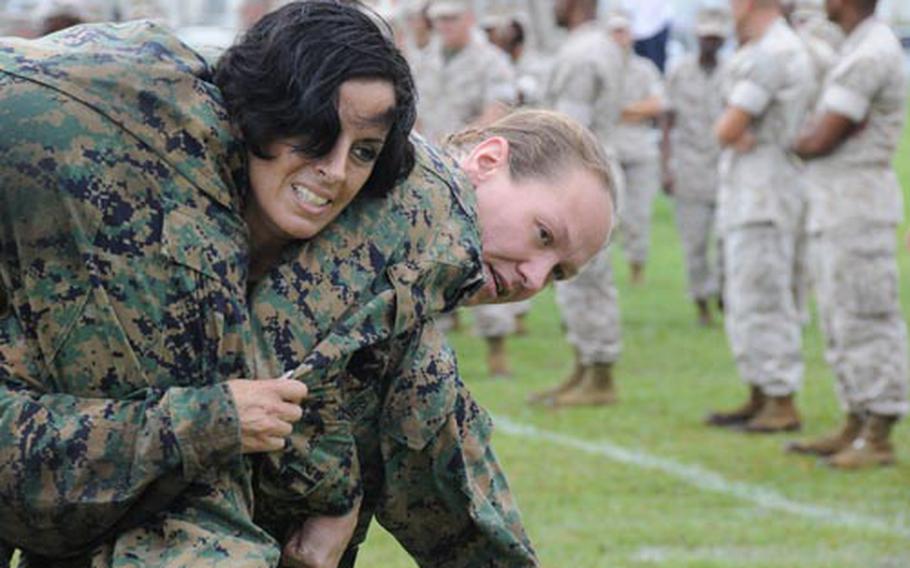 Gunnery Sgt. Theresa Chapman, 40, from Stamford. Conn., carries Gunnery Sgt. Sharon Braun, 34, from Rockville, Conn., in a fireman's carry during the maneuver-under-fire portion of the Marine Corps' new combat fitness test. The Tuesday demonstration of the Corps' new test took place at Camp Foster, Okinawa. Both Marines are assigned to Headquarters Battalion, Marine Corps Base Camp Butler.
