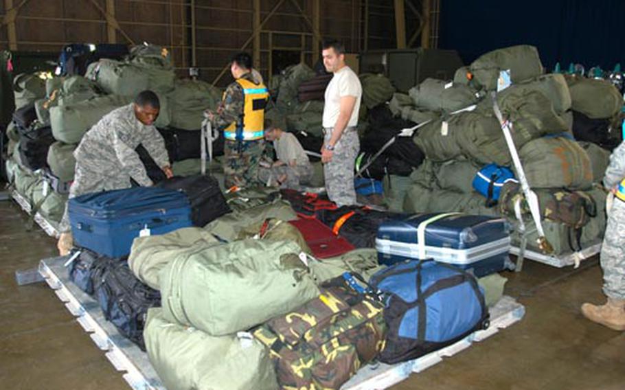 Airmen at Misawa Air Base, Japan, help pile luggage on cargo pallets Sunday morning. Airmen and their bags deployed to Iraq Sunday in support of the 14th Fighter Squadron. More than 300 airmen are part of the deployment, scheduled to last four to five months.
