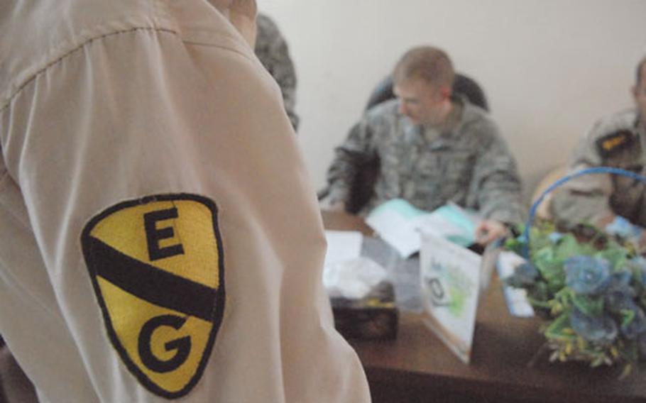 The patch of a "Sons of Iraq" member from Baghdad’s Ghazaliya neighborhood stands out while the man waits for his file to be reviewed Tuesday by Capt. Thomas Melton, commander of A Troop, 1st Squadron, 75th Cavalry Regiment. "Sons of Iraq" from the area are called "Ghazaliya Guardians." The "E" on the patch means this man works in the east sector of the neighborhood.