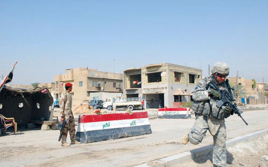 Spc. Adam Teske, a soldier in Company E, 1st Battalion, 22nd Infantry Regiment, passes by an Iraqi Army checkpoint during a patrol Sunday in the Jihad area of Baghdad. The Iraqi Army will soon take charge of the "Sons of Iraq," who man the area’s other checkpoints.