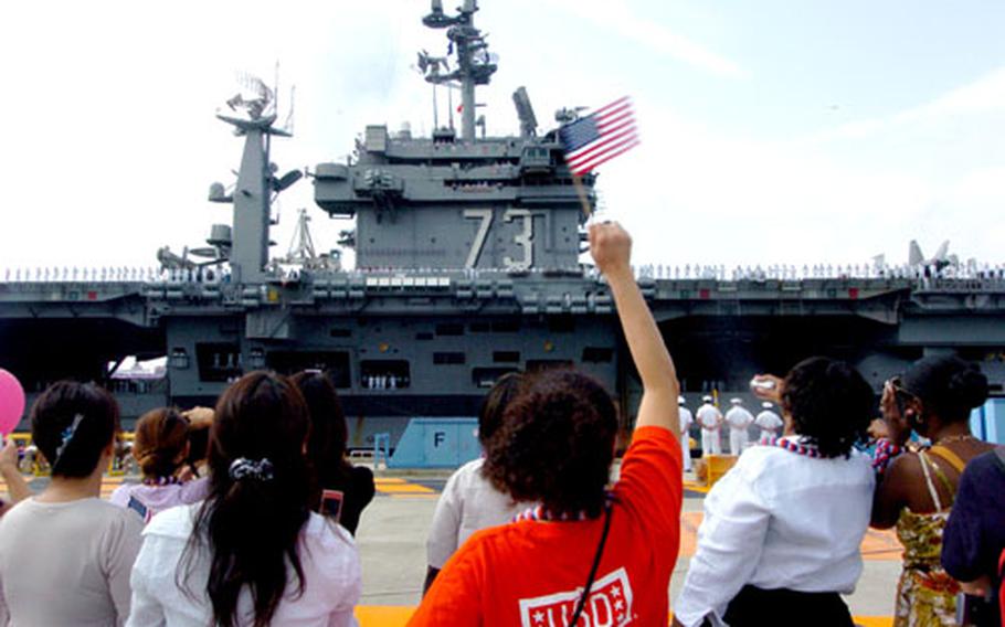 Friends and family members cheer the Thursday morning arrival of USS George Washington at Yokosuka.
