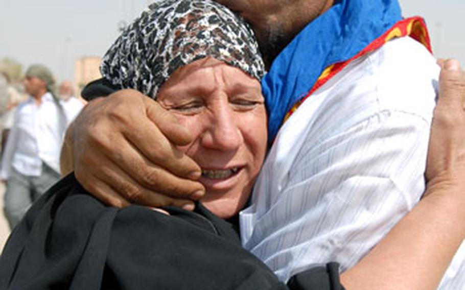 Mohammad Afon Ali hugs his mother Thursday in Baghdad’s Ghazaliyah neighborhood en route to sign the papers that will make him a free man. Ali was one of about 75 detainees allowed to return to the community under a supervised release program.
